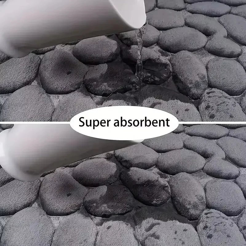 Alfombrilla de baño gris de Variedad Online con diseño de guijarros, súper absorbente y de secado rápido.
