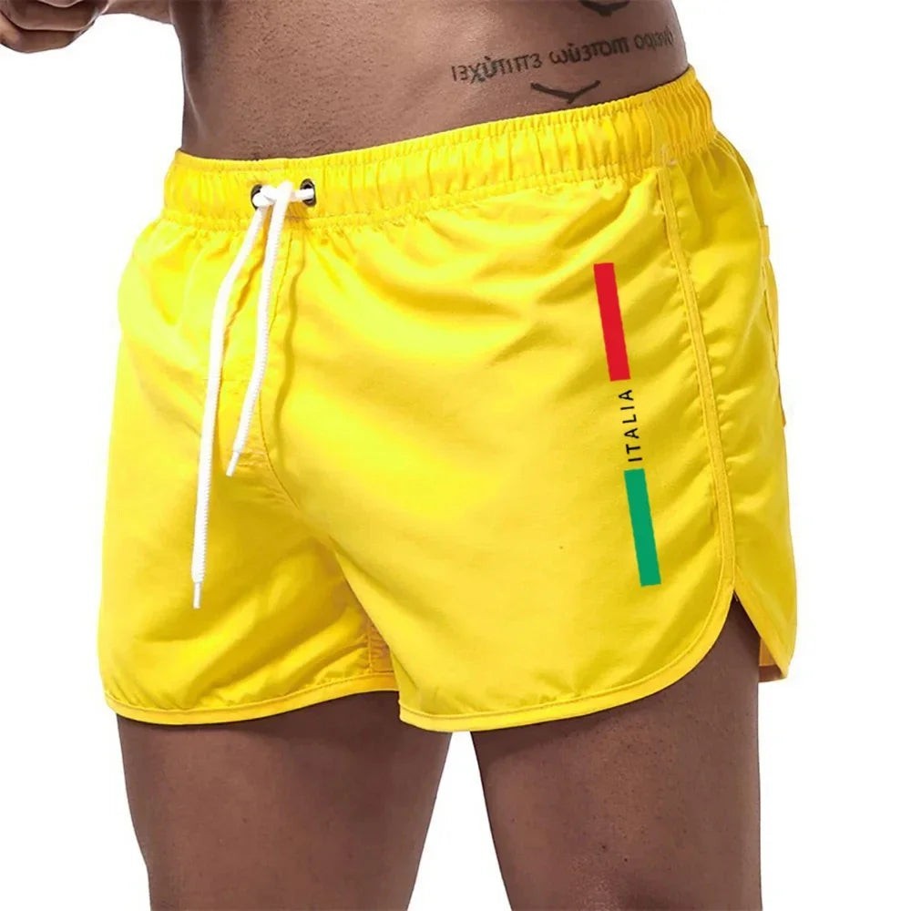 Bañadores amarillos de secado rápido para hombre de Variedad Online con detalle de bandera italiana y cordón ajustable.