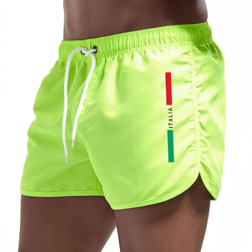 Bañadores cortos de secado rápido para hombre de Variedad Online en color verde lima con detalle de bandera italiana y cordón ajustable.