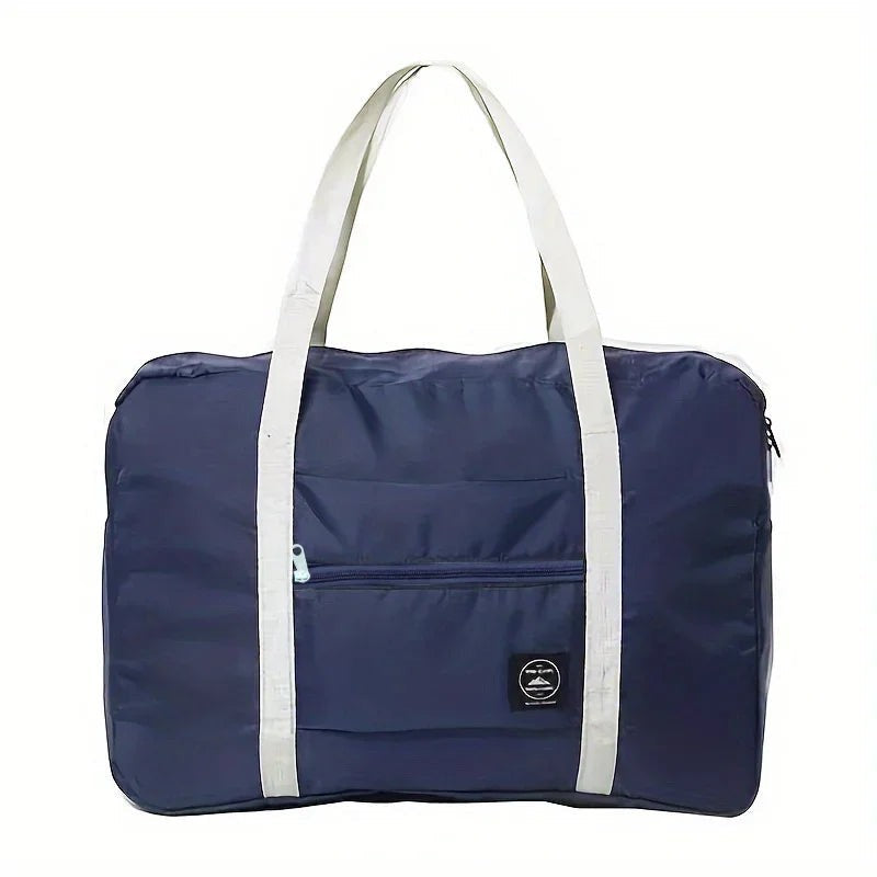 Bolsa de viaje plegable azul marino de nailon resistente al agua con asas blancas y bolsillo frontal con cremallera. Variedad Online.