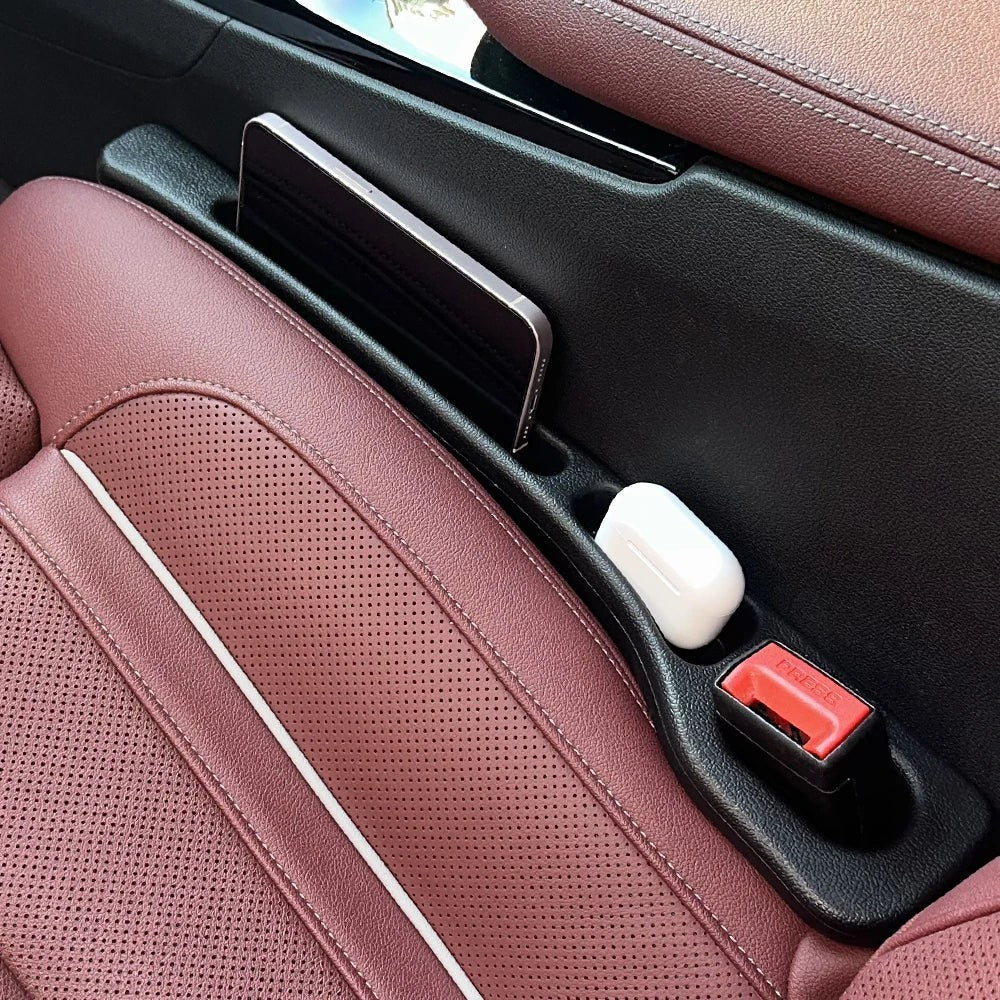 Organizador de huecos para asientos de coche Variedad Online en cuero burdeos con compartimentos para teléfono y auriculares.
