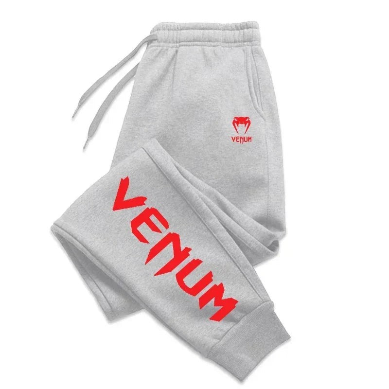 Pantalones de chándal grises de entrenamiento Venum para hombre con cordón ajustable y logo rojo en el muslo.